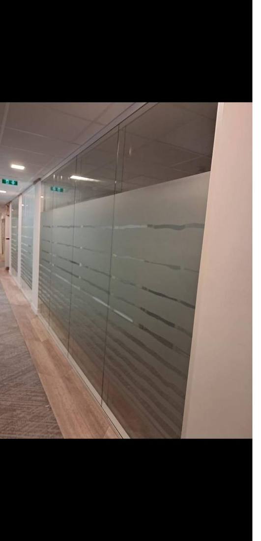 Cloisons vitrées d'un couloir de bureaux avec film dépoli à bandes horizontales posé par DFP France — confidentialité partielle