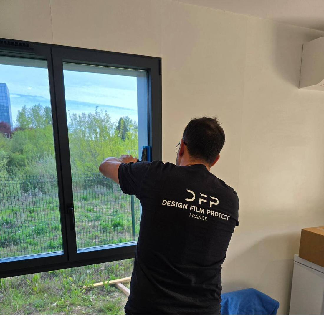 Technicien DFP France posant un film solaire sur une baie vitrée